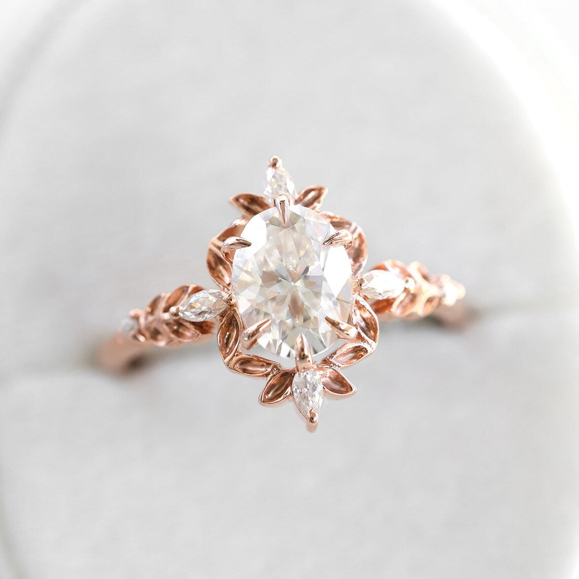 Close-up of Oval Diamond Engagement Ring with marquise white Diamonds and lab/natural diamond.