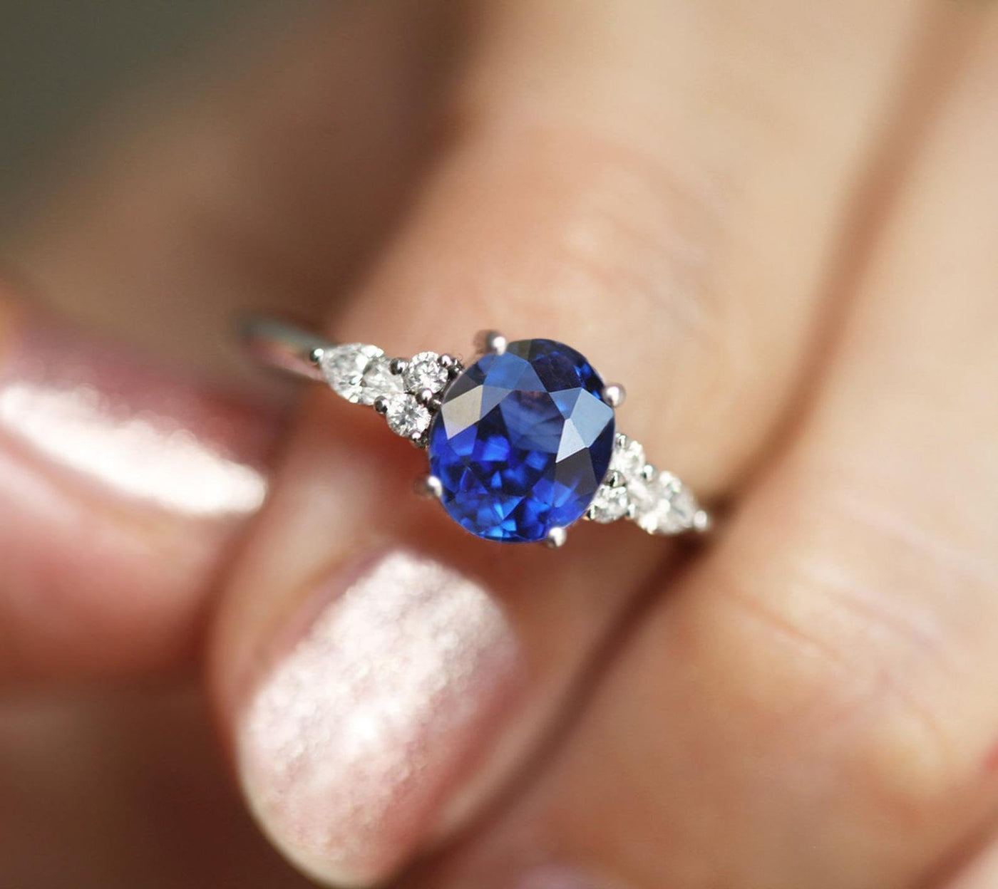 Oval sapphire cluster ring with white side diamonds