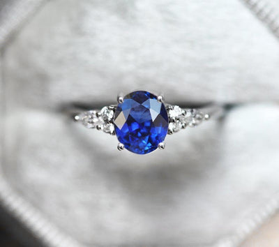 Oval sapphire cluster ring with white side diamonds