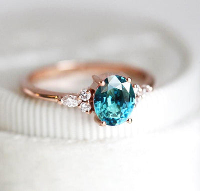 Oval teal sapphire ring with white side diamonds