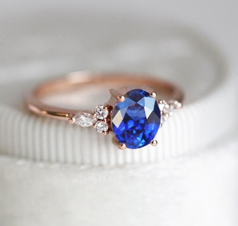 Oval sapphire cluster ring with white side diamonds