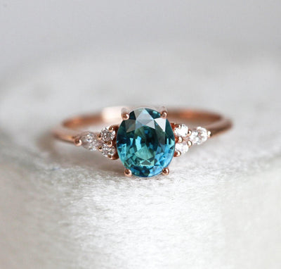 Oval teal sapphire ring with white side diamonds