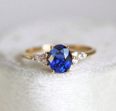 Oval sapphire cluster ring with white side diamonds