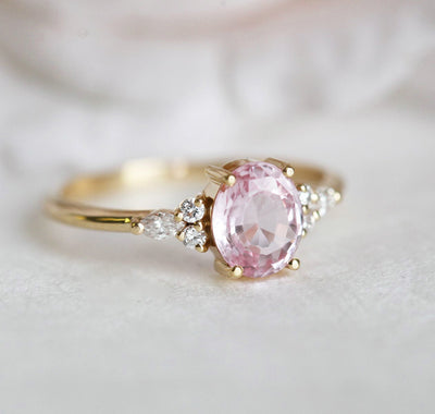 Oval peach sapphire ring with white side diamonds