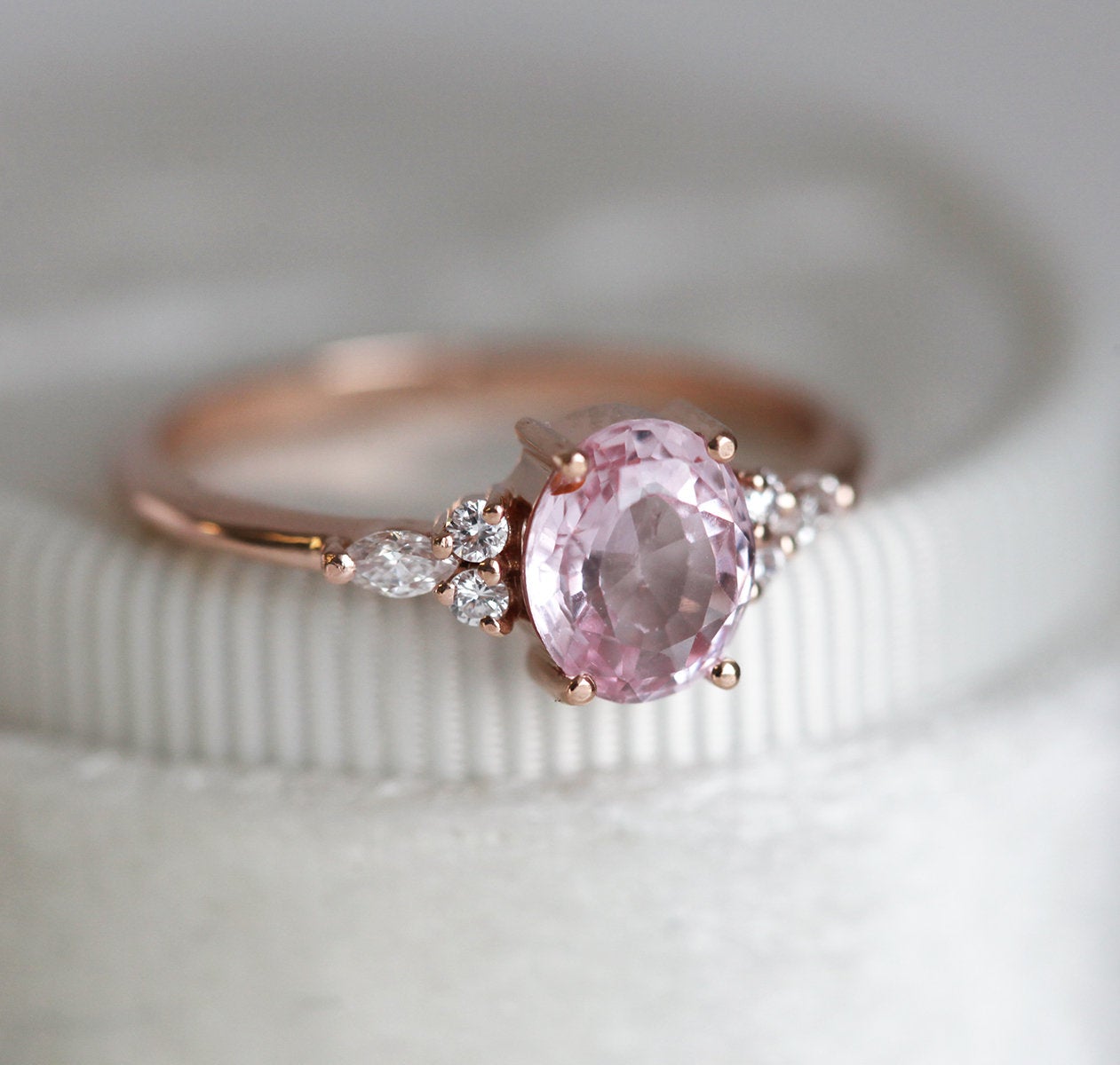 Oval peach pink sapphire with white side diamonds