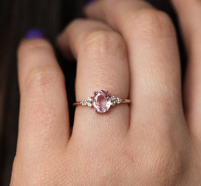 Oval peach pink sapphire with white side diamonds