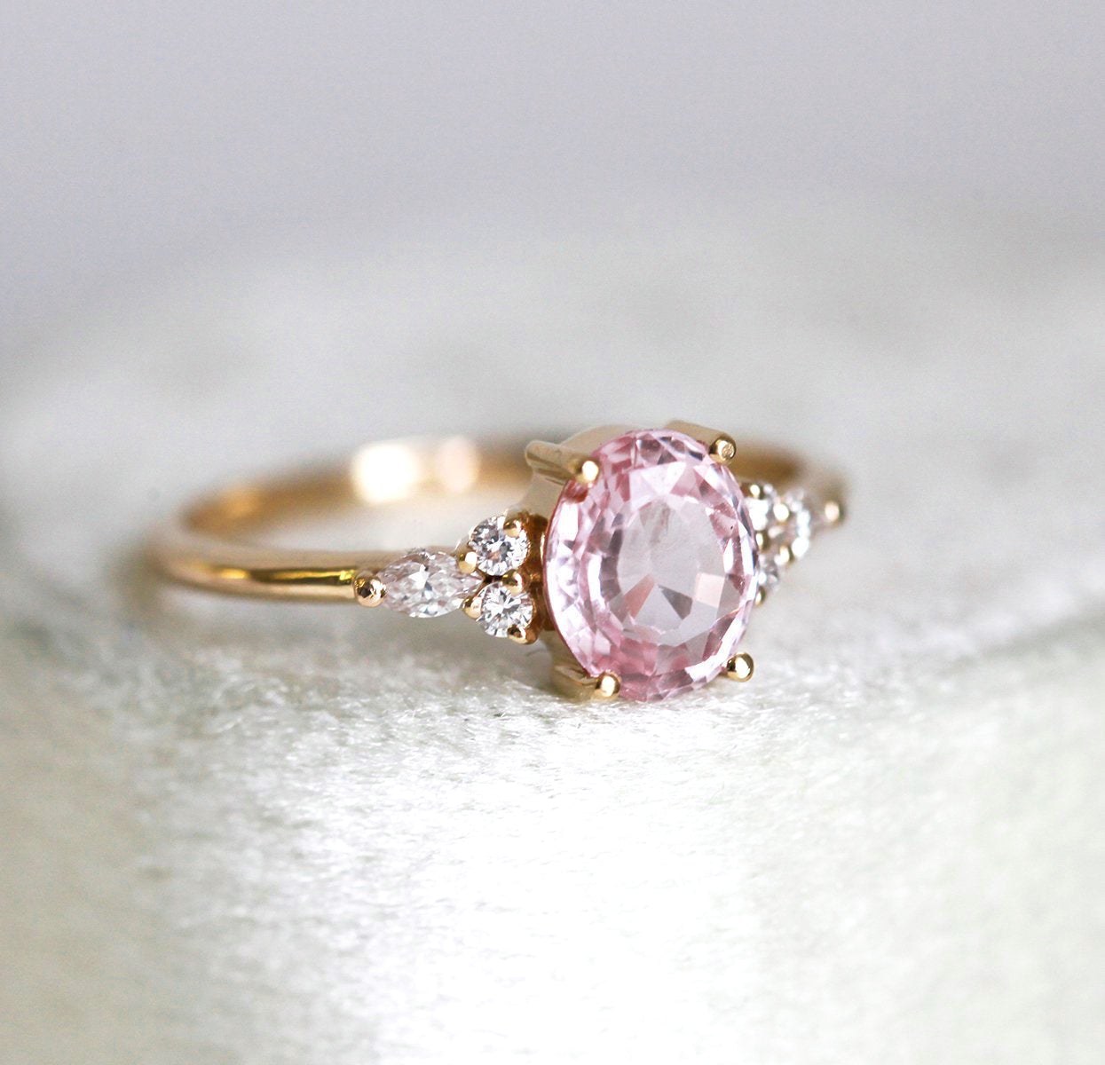 Oval peach pink sapphire with white side diamonds