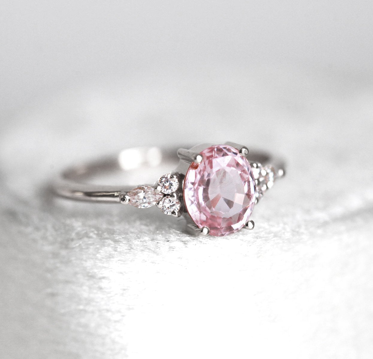 Oval peach pink sapphire with white side diamonds