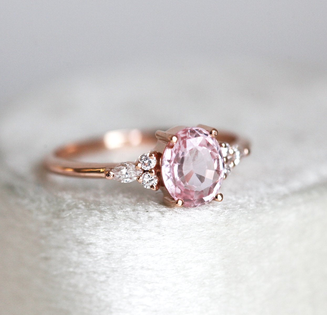 Oval peach pink sapphire with white side diamonds