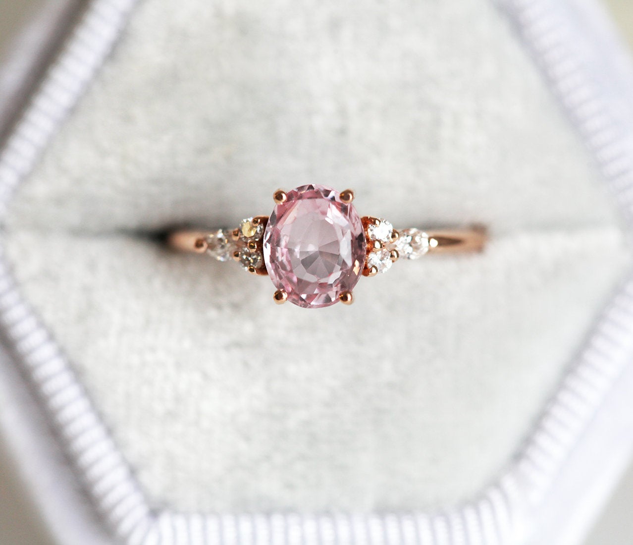 Oval peach pink sapphire with white side diamonds