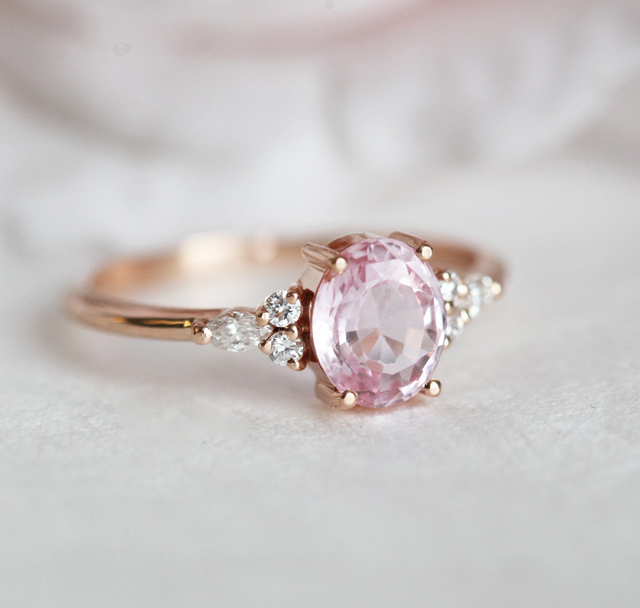 Oval peach pink sapphire with white side diamonds