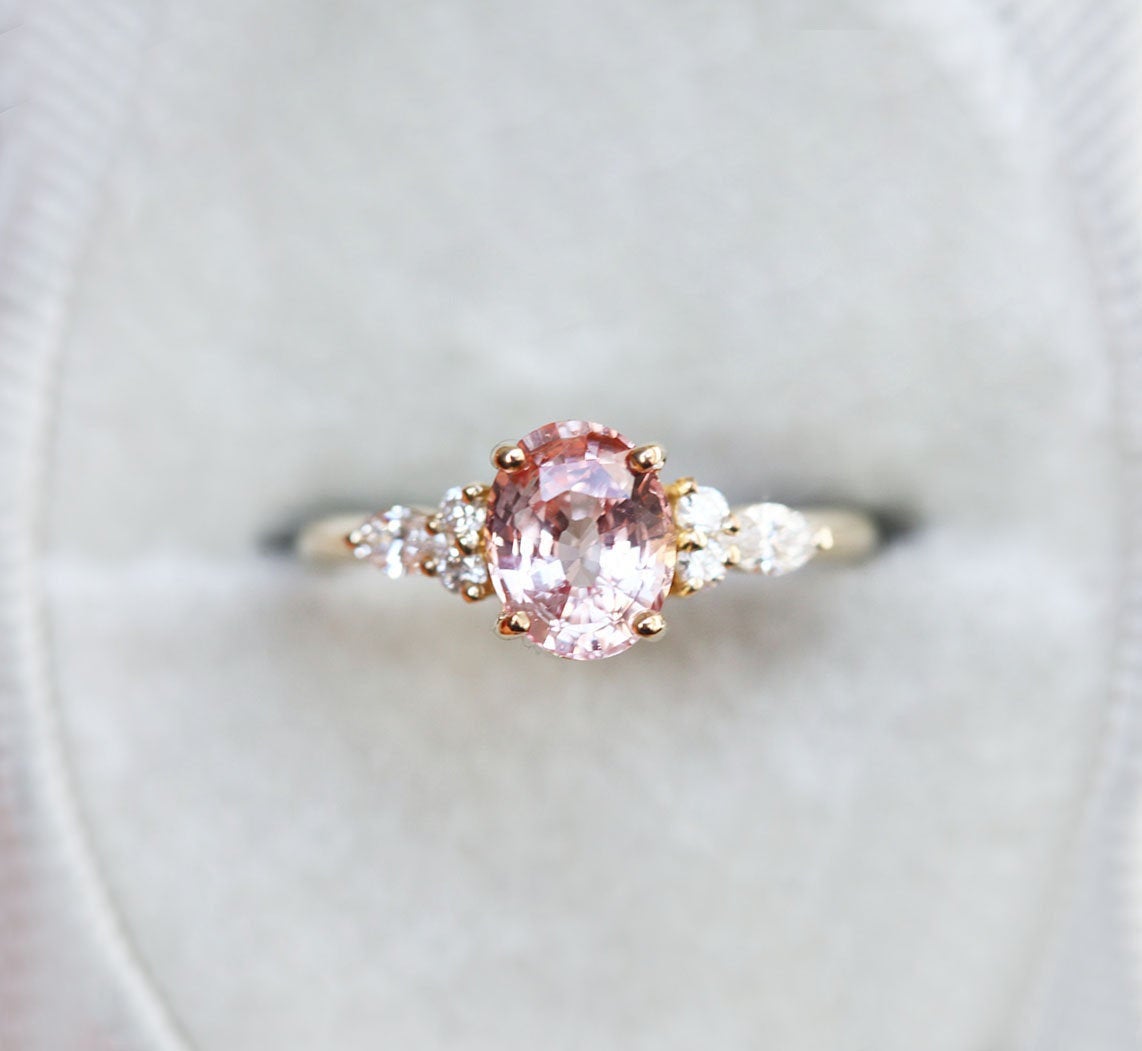 Oval peach sapphire ring with white side diamonds