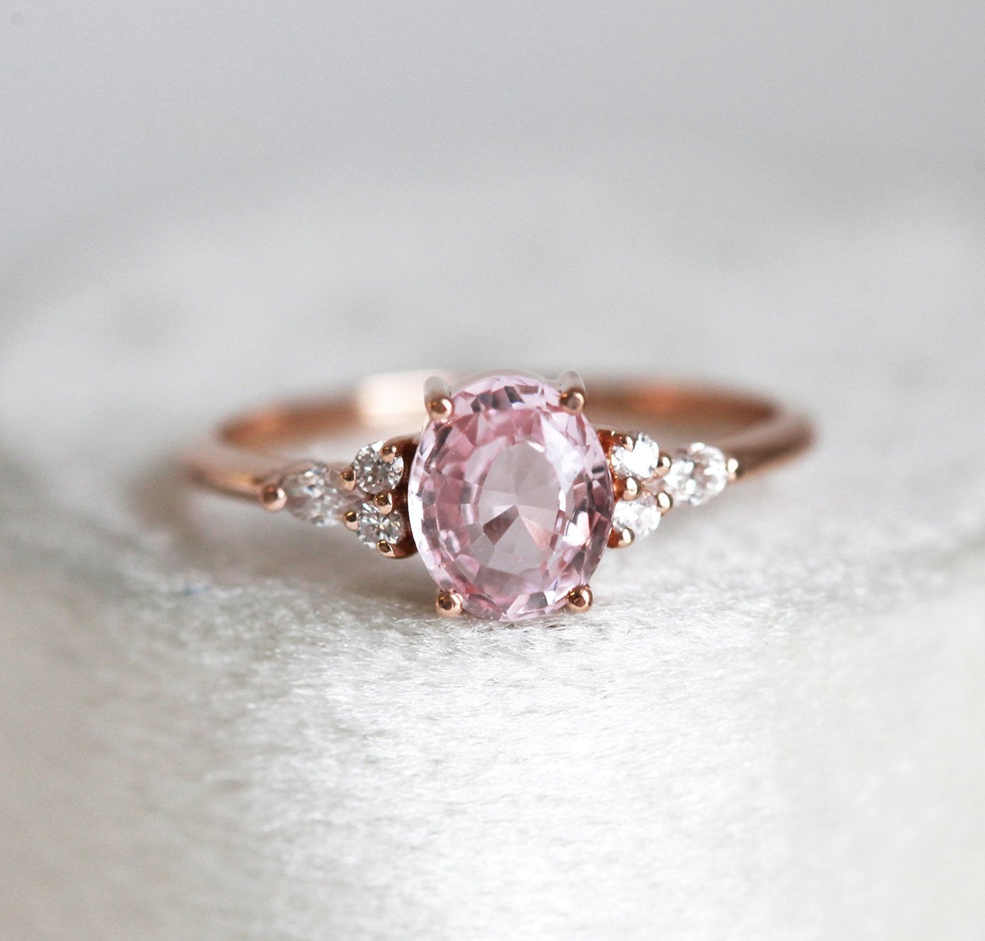 Oval peach pink sapphire with white side diamonds