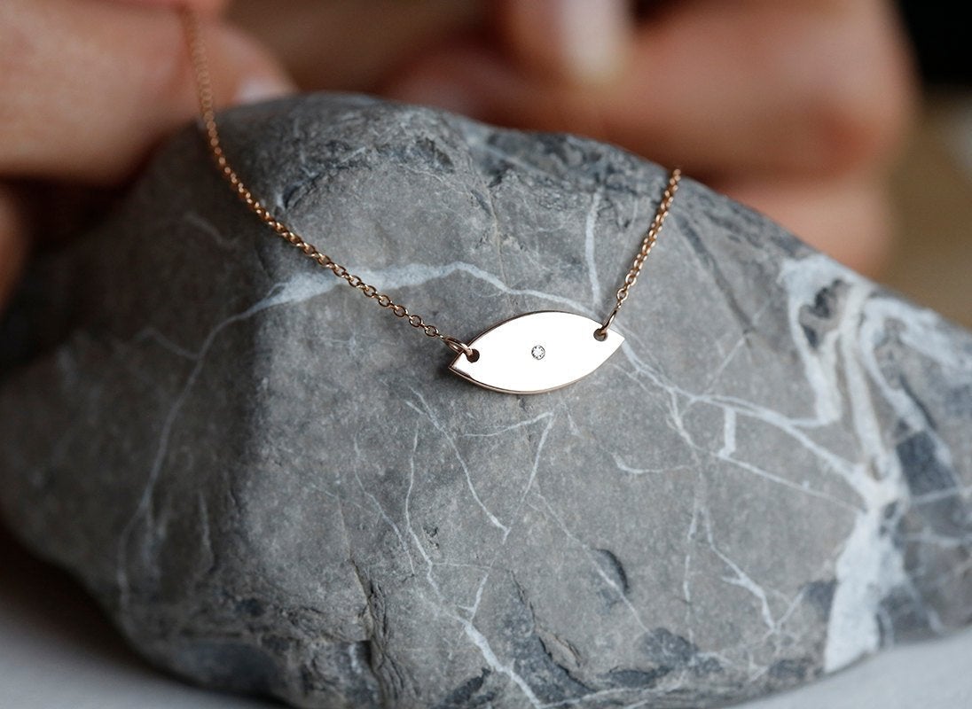 Evil eye gold necklace with round white diamond