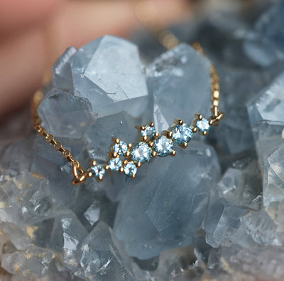 Gold chain bracelet with round blue topaz cluster