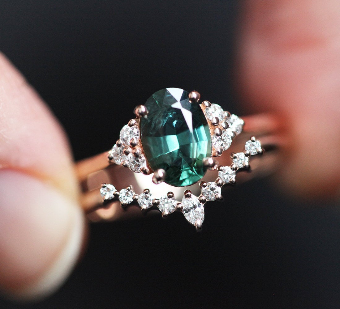 Oval teal sapphire cluster ring with diamonds