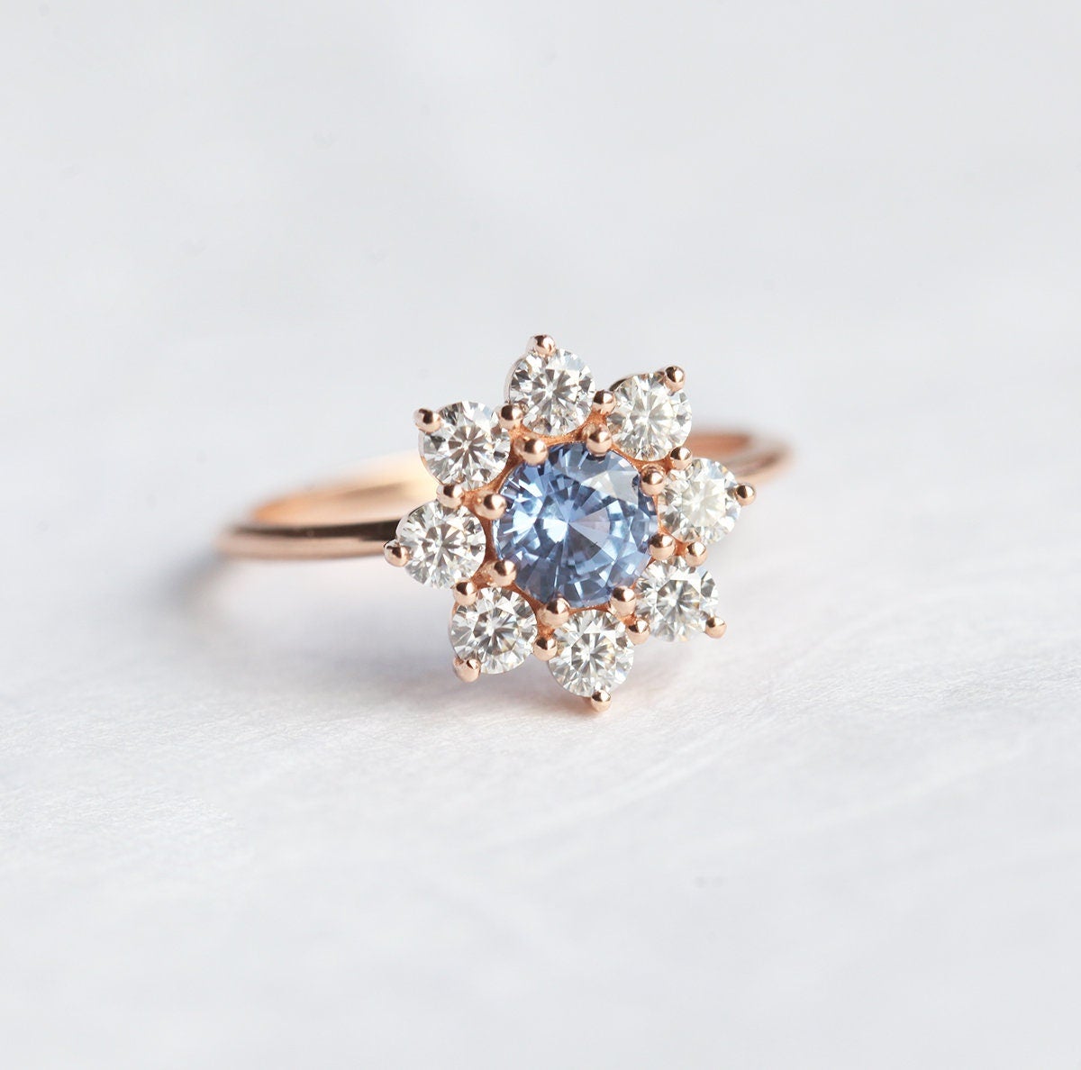 Round light blue sapphire ring with diamond halo
