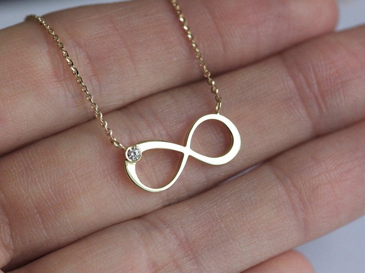 Infinity Symbol Gold Necklace with a Round White Diamond attached to the symbol