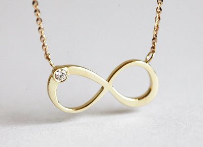 Infinity Symbol Gold Necklace with a Round White Diamond attached to the symbol
