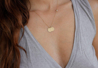 Gold necklace with layered discs, initials and white round diamond