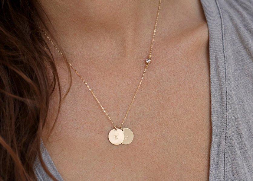Gold necklace with layered discs, initials and white round diamond