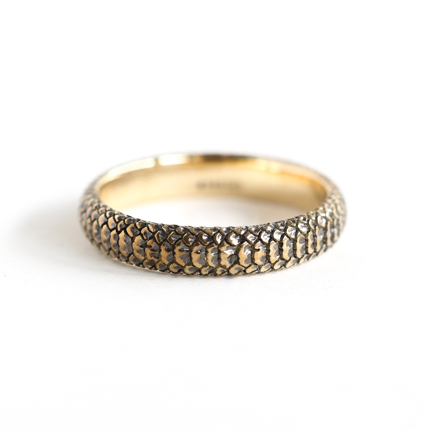 Gold snake band textured ring, close-up shot showcasing intricate snake skin pattern. Crafted in 14k & 18k gold, with customization options for gemstones.