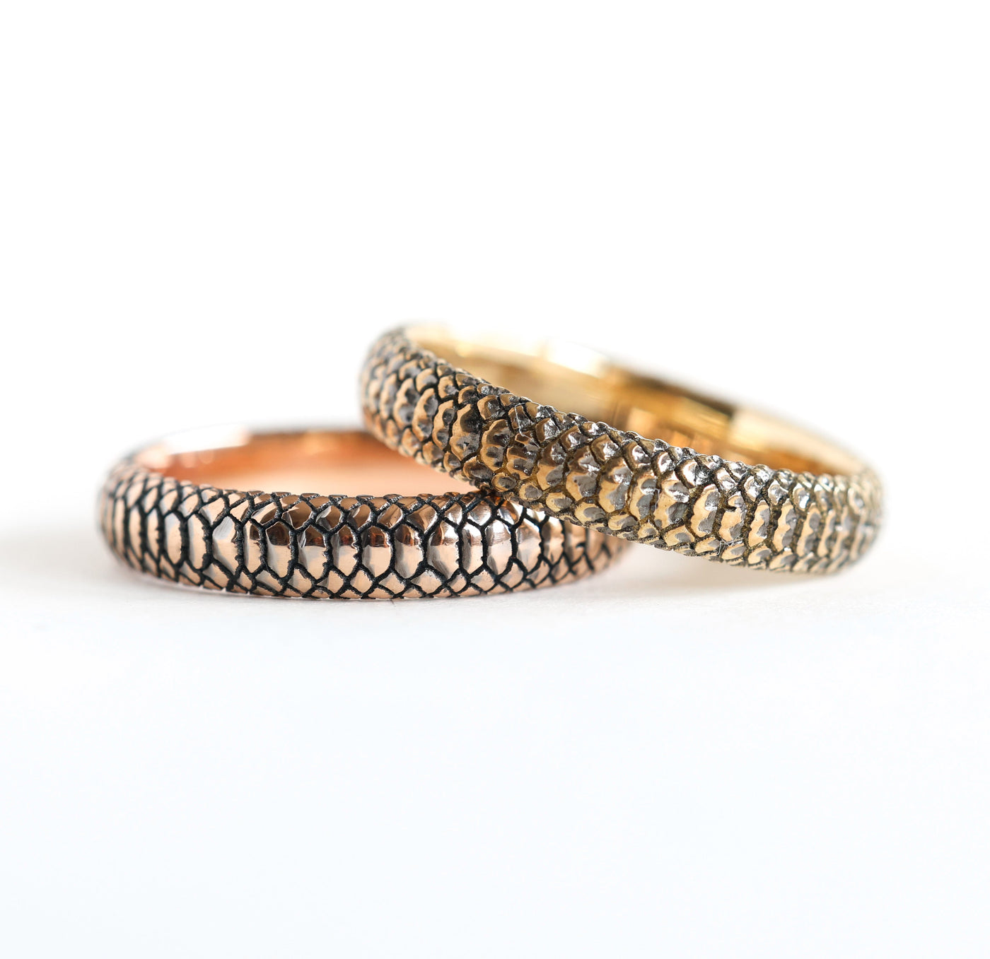 Close-up of a unique gold snake band ring with textured design. Band width options: 3mm, 4mm, 5mm, 6mm. Material choices include 14k or 18k gold and platinum. Customizable with gemstones.