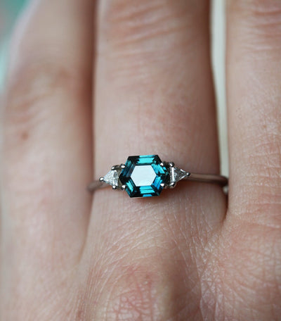 Hexagon-shaped teal sapphire ring with side diamonds