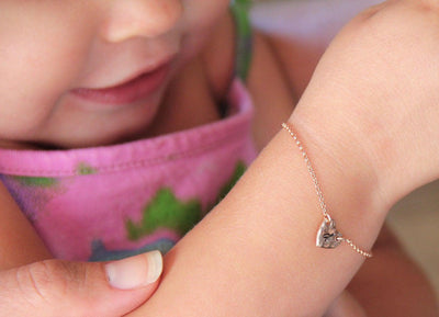 Infant's rose gold chain bracelet with heart charm and personalized initial letter