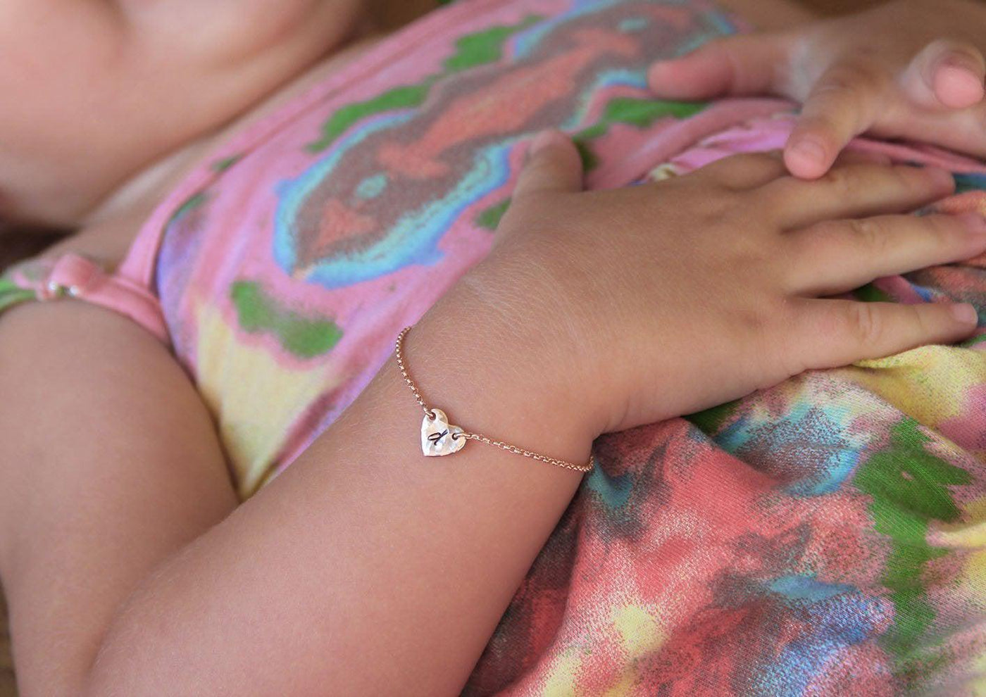 Infant's rose gold chain bracelet with heart charm and personalized initial letter