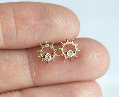 Round white diamond inside sun-shaped gold stud earrings