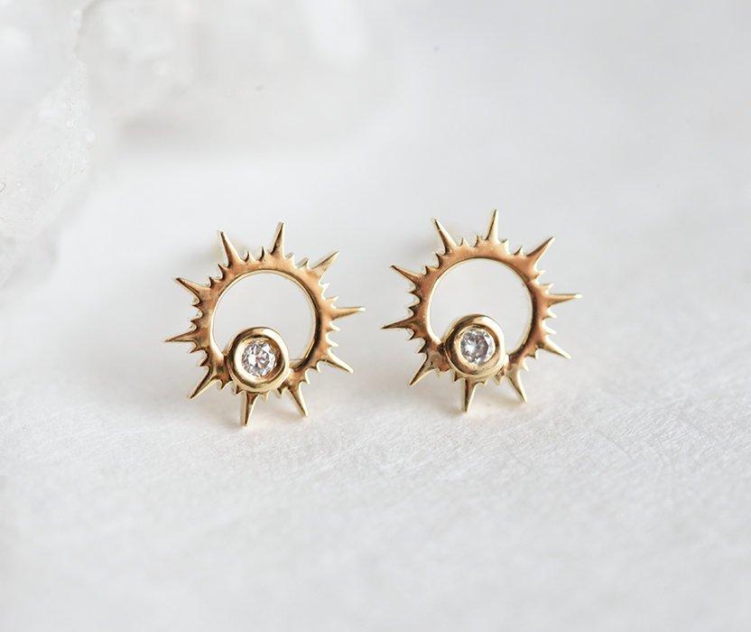 Round white diamond inside sun-shaped gold stud earrings