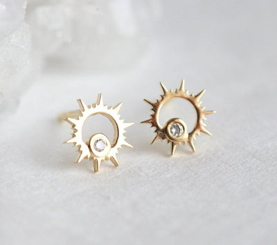 Round white diamond inside sun-shaped gold stud earrings