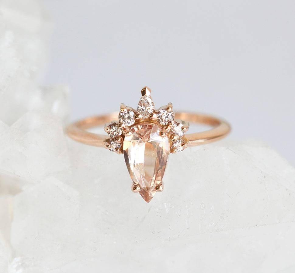 Pear-shaped peach sapphire ring with diamond halo