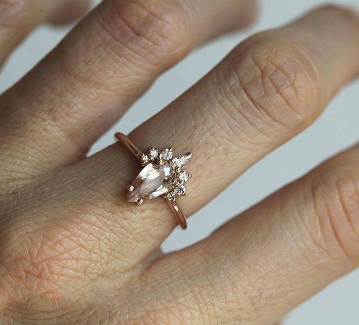 Pear-shaped peach sapphire ring with diamond halo