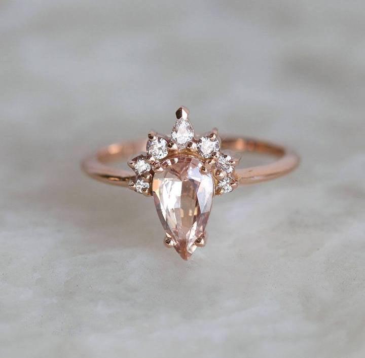 Pear-shaped peach sapphire ring with diamond halo