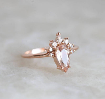 Pear-shaped peach sapphire ring with diamond halo