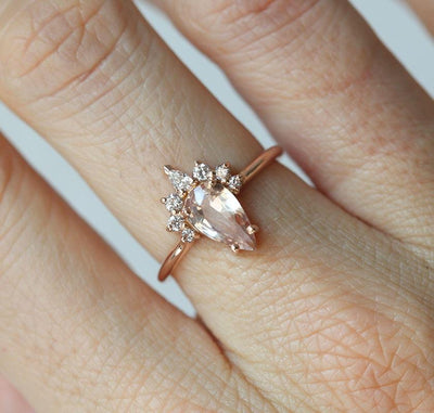 Pear-shaped peach sapphire ring with diamond halo