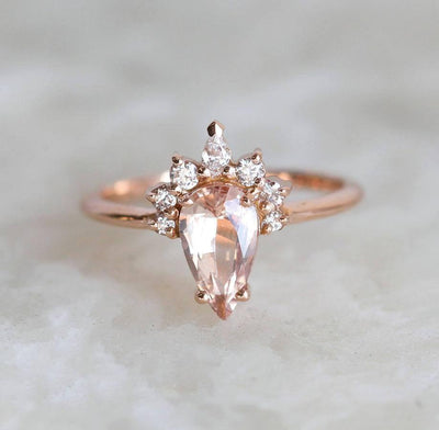 Pear-shaped peach sapphire ring with diamond halo