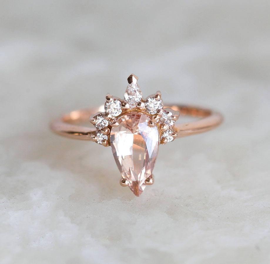 Pear-shaped peach sapphire ring with diamond halo