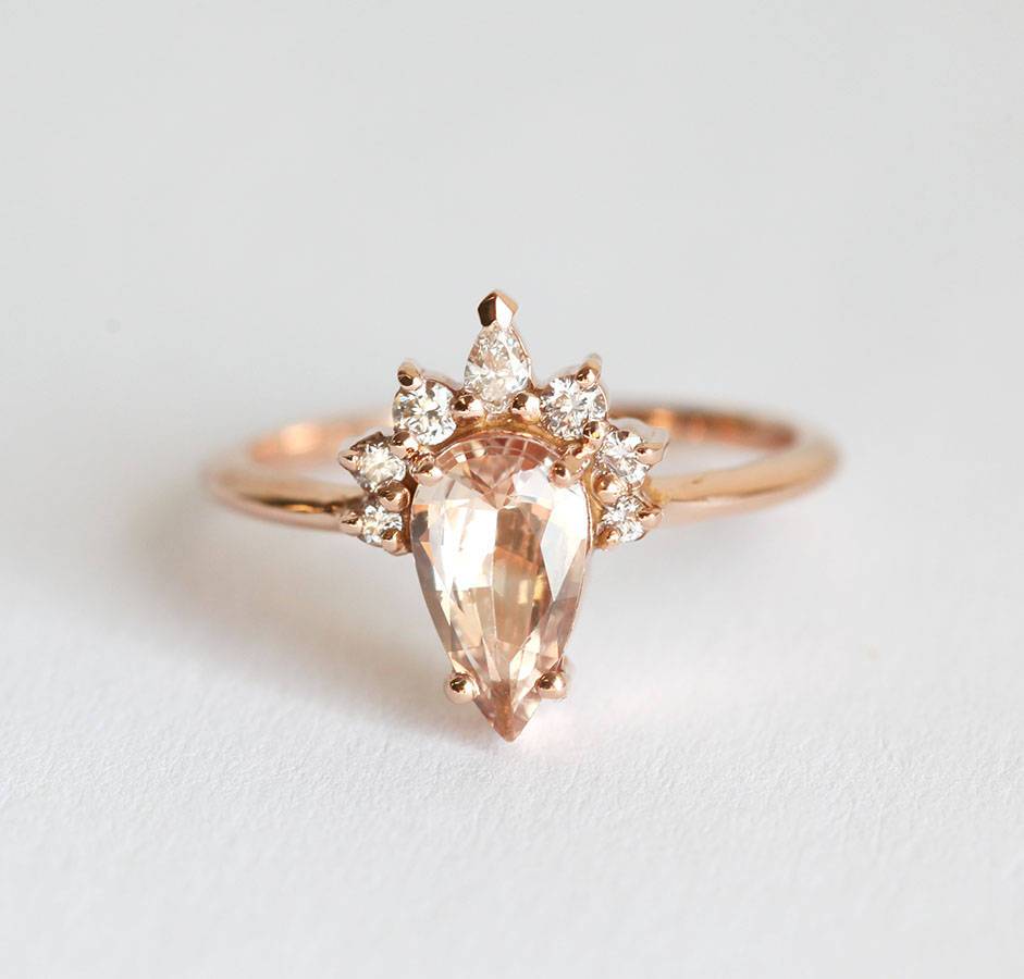 Pear-shaped peach sapphire ring with diamond halo