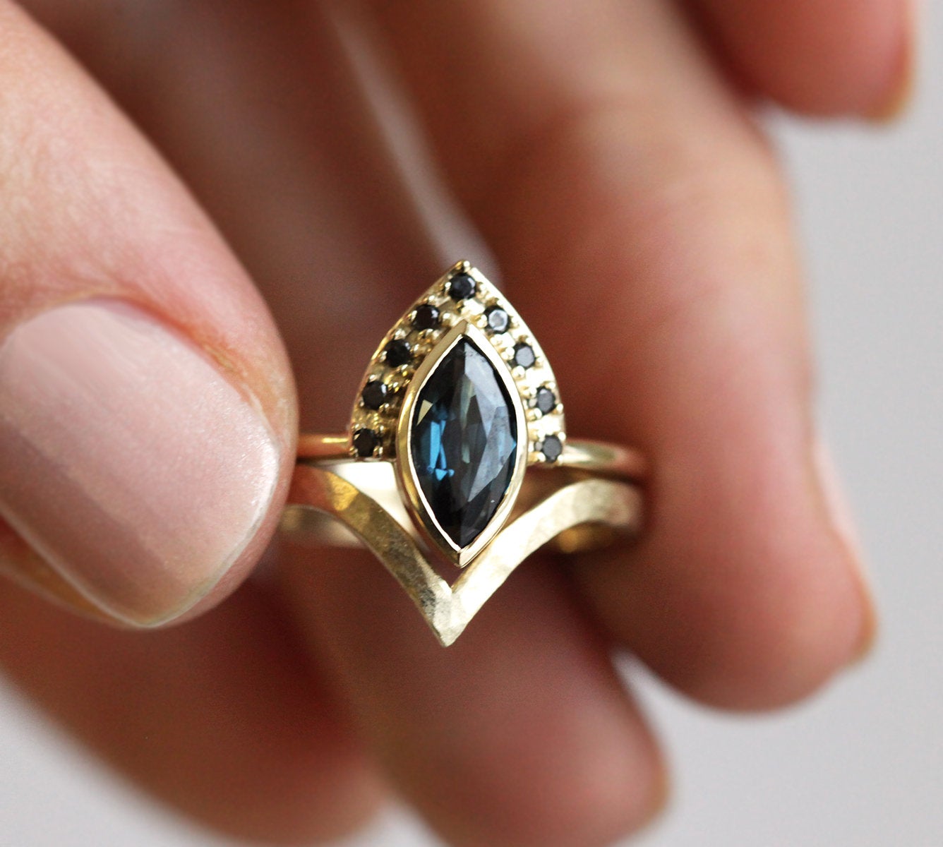 Blue marquise-shaped sapphire ring with diamond halo