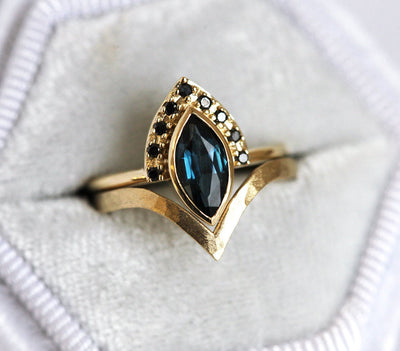 Blue marquise-shaped sapphire ring with diamond halo