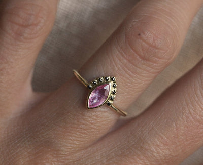 Pink marquise-shaped sapphire ring with black diamond halo