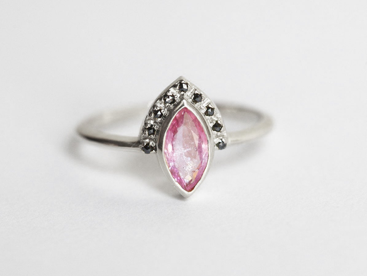 Pink marquise-shaped sapphire ring with black diamond halo