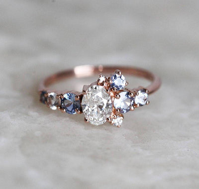 Oval-shaped white diamond cluster ring with sapphires