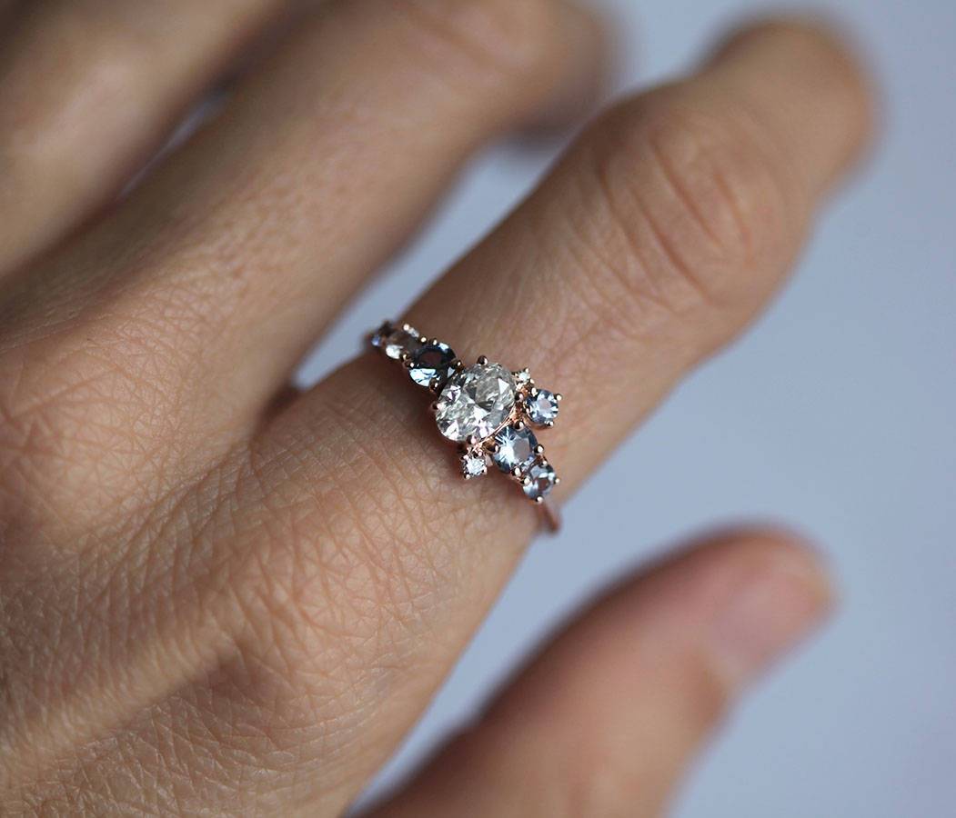 Oval-shaped white diamond cluster ring with sapphires