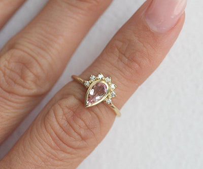 Pear-shaped pink sapphire with diamond halo