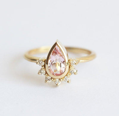 Pear-shaped pink sapphire with diamond halo