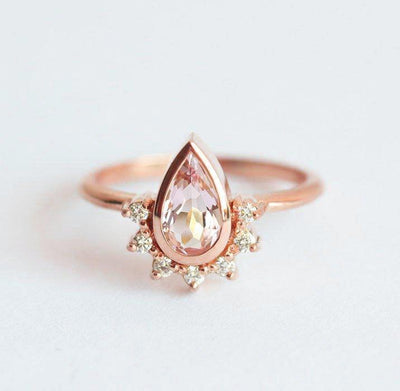 Pear-shaped pink sapphire with diamond halo